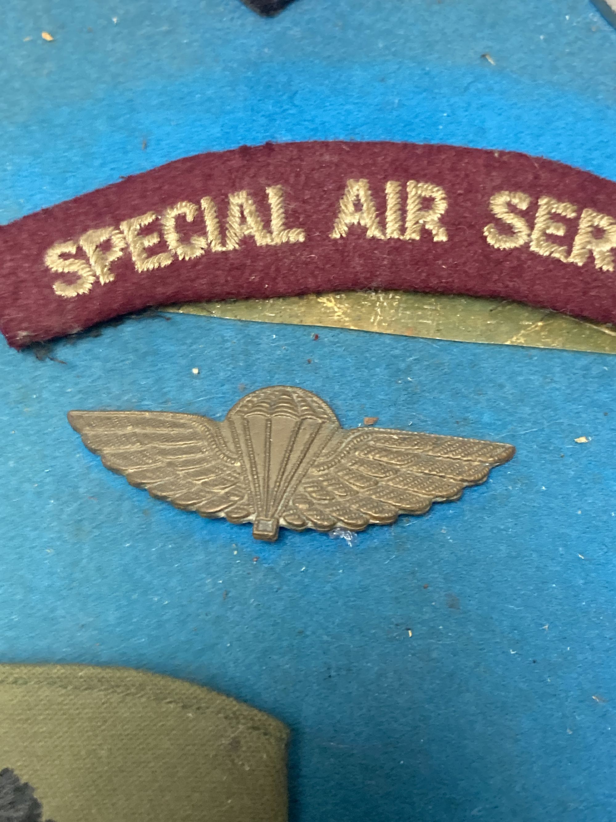 A group of Special Air Service SAS embroidered insignia, a belt and other military items, includes a Malayan Scouts insignia and a group of unnamed miniatures
